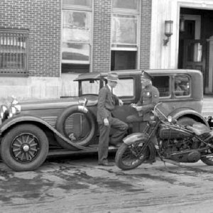 Traffic officer with Auto Stutz Police Cycle in front of headquarters building 1928.